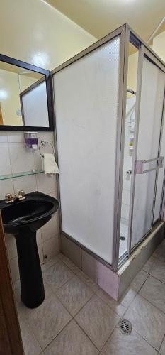 een badkamer met een douche en een zwarte wastafel bij Departamento Amplio con todo lo necesario in Latacunga