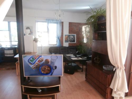 a living room with a tv and a desk with a table at Private Apartment For You in Tartu