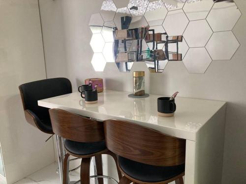 a kitchen with a bar with two stools at Modern Simplicity: Cozy @Nuvali in Pitland