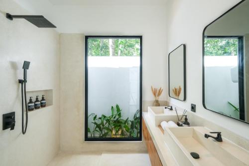 a bathroom with two sinks and a large window at Villa Neptune Uluwatu in Uluwatu