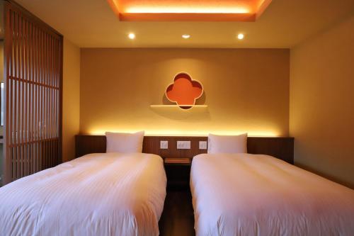 two beds sitting next to each other in a room at Yamagataya in Gero