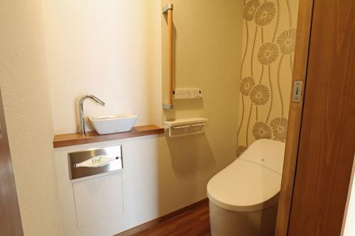 a small bathroom with a toilet and a sink at Yamagataya in Gero