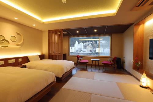 a hotel room with two beds and a projection screen at Yamagataya in Gero