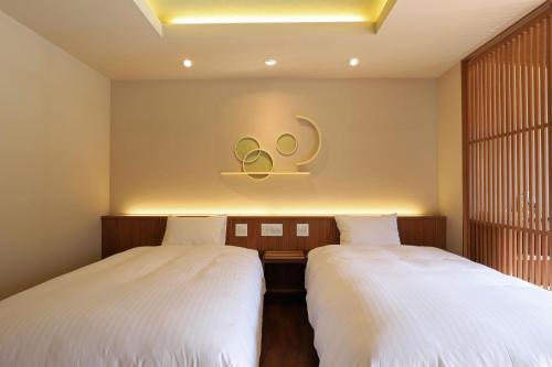 two beds sitting next to each other in a room at Yamagataya in Gero
