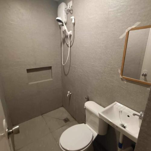 a bathroom with a shower and a toilet and a sink at Transit Inn in Dagupan