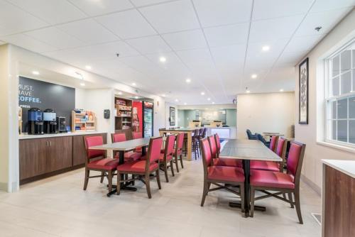 a restaurant with red chairs and tables and a counter at Holiday Inn Express - Plymouth by IHG in Plymouth