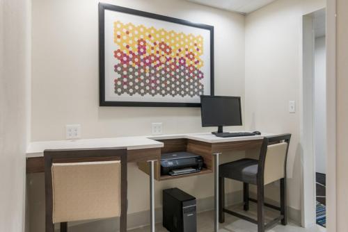 a room with a desk with a computer and chairs at Holiday Inn Express - Plymouth by IHG in Plymouth