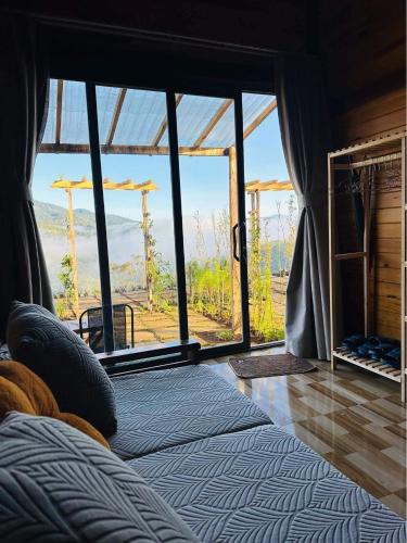 a bedroom with a bed with a view of a mountain at TopView Măng Đen in Kon Von Kla
