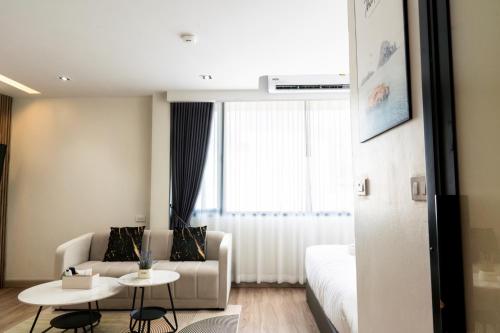 a living room with a couch and a bed at indigo Hotel Hatyai in Ban Kohong