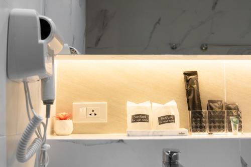 a shelf with a phone and other items on it at indigo Hotel Hatyai in Ban Kohong