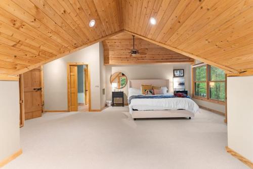 Private Cabin at Lake Hartwell في Townville: غرفة نوم بسرير وسقف خشبي