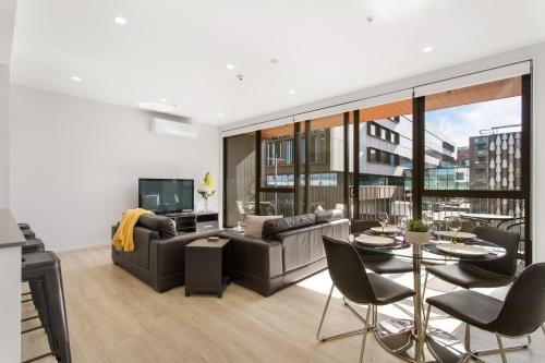 a living room with a couch and a table at Heart of the CBD 2Bdrms 2Bthrms secure park in Christchurch