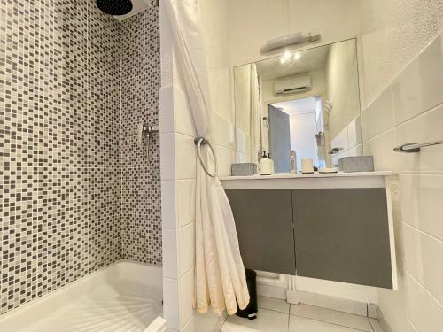 une salle de bain avec une douche avec un lavabo et un miroir dans l'établissement Superbe 2 pièces à 200m de la plage avec terrasse et parking - FR-1-338-533, à Sète