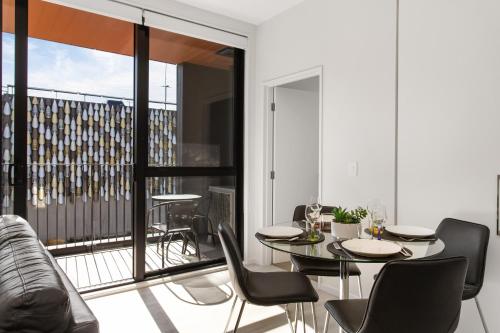 a living room with a table and chairs and a balcony at Heart of the CBD 2Bdrms 2Bthrms secure park in Christchurch