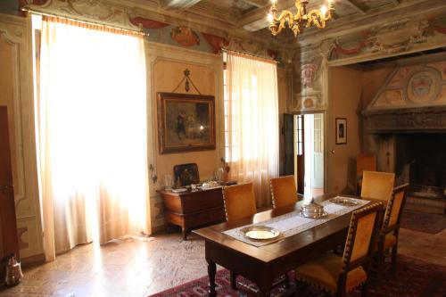 a dining room with a table and chairs and a fireplace at Palazzo Tornielli in Mombello Monferrato