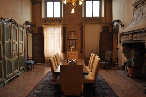 a dining room with a table and chairs and a chandelier at Palazzo Tornielli in Mombello Monferrato