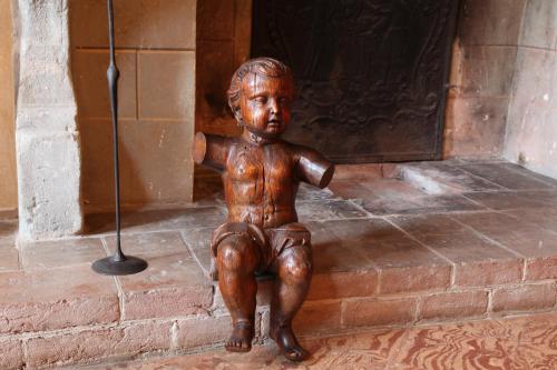 a statue of a little boy sitting in front of a door at Palazzo Tornielli in Mombello Monferrato
