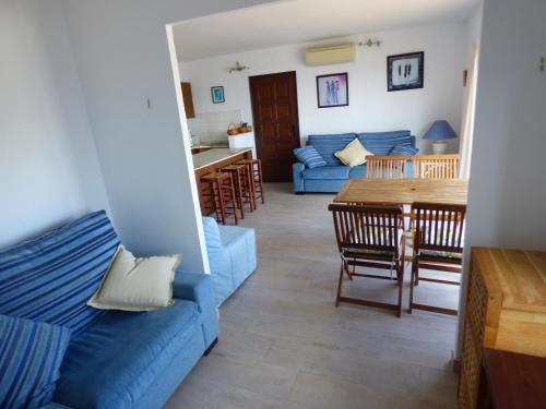 - un salon avec un canapé bleu et une table dans l'établissement "La Terrasse de la mer 8" -Climatisation-Wifi-BBQ -Piscine-Parking, à Begur