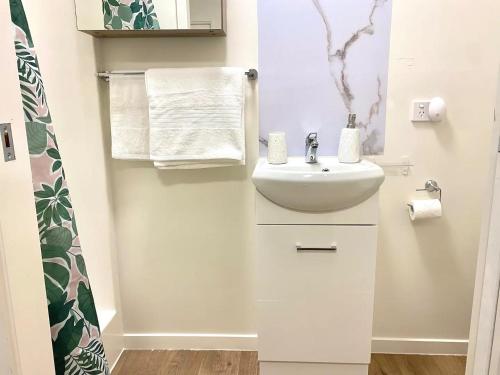La salle de bains blanche est pourvue d'un lavabo et d'un miroir. dans l'établissement Entire Self-Contained Cabin on the Beautiful Mountain, à Mount Tamborine