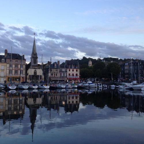 a group of boats in a harbor with a city at Chambres chez l'habitant Capucine in Honfleur