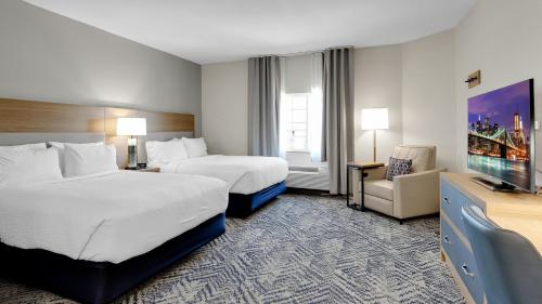 a hotel room with two beds and a television at Candlewood Suites San Antonio Downtown by IHG in San Antonio