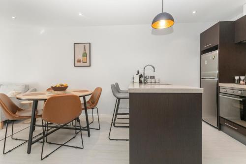 a kitchen with a table and chairs in a kitchen at Feel at Home with Aircon, Pool, Gym, WiFi in Auckland
