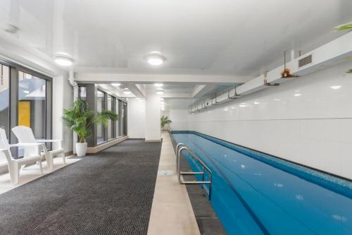 a swimming pool in a office building with a swimming pooliterator at Feel at Home with Aircon, Pool, Gym, WiFi in Auckland