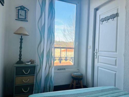 - une chambre avec une fenêtre donnant sur un balcon dans l'établissement Charmant T2 Méditerranéen à deux pas des quais – Port-Vendres - FR-1-309-436, à Port-Vendres