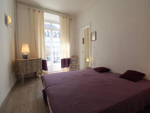 a bedroom with a purple bed and a window at Appartement Bagnères-de-Luchon, 2 pièces, 4 personnes - FR-1-313-230 in Luchon