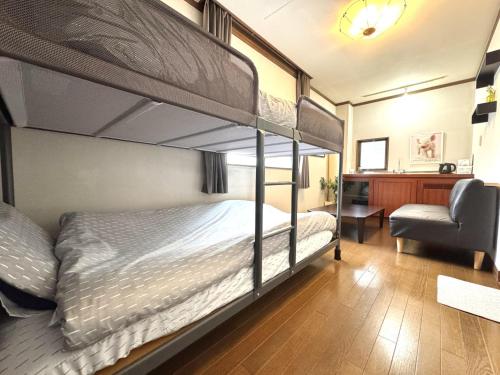 1 dormitorio con 2 literas y 1 silla en Best location !private room in Jujo shopping street for max 6 people, en Tokio