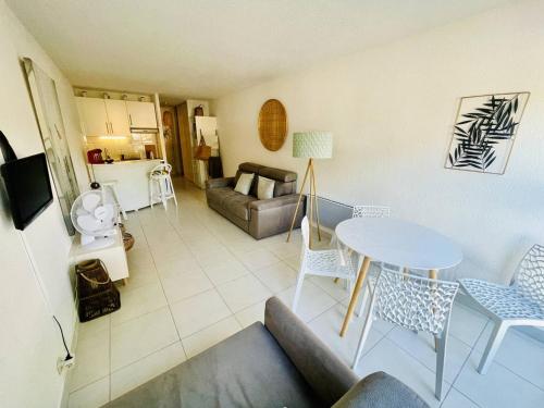 un salon avec un canapé, une table et des chaises dans l'établissement Studio centre port avec piscine et parking - FR-1-723-146, au Cap d'Agde