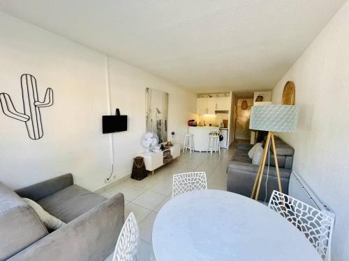 un salon avec un canapé et une table dans l'établissement Studio centre port avec piscine et parking - FR-1-723-146, au Cap d'Agde