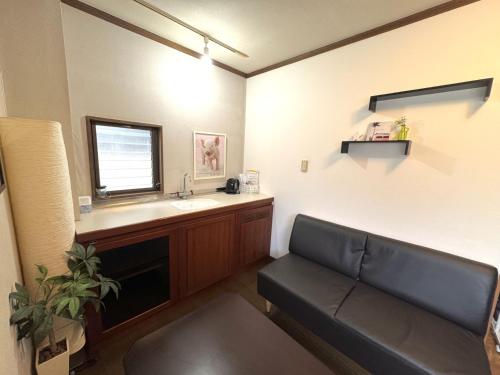 sala de estar con sofá y lavamanos en Best location !private room in Jujo shopping street for max 6 people, en Tokio
