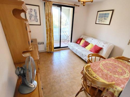 - un salon avec un canapé et un ventilateur dans l'établissement Appartement T2 avec Piscine, Tennis, Parking - 200m Plages et Commerces - FR-1-316-333, à Six-Fours-les-Plages