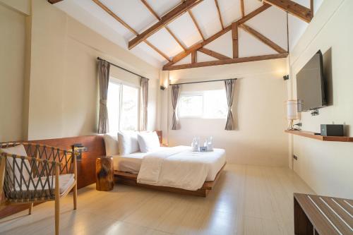 愛妮島的住宿－Nacpan Beach Villas，一间卧室配有一张床,并在一间客房内配有电视。