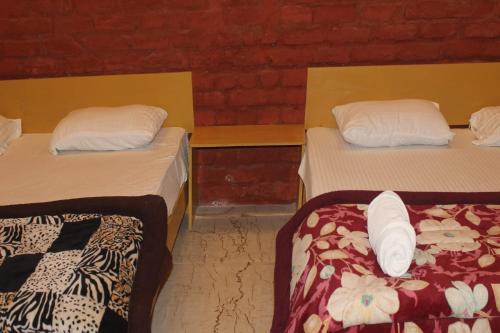 two beds in a room with two beds sidx sidx sidx at corbett jungle safari & homestay in Jhirna