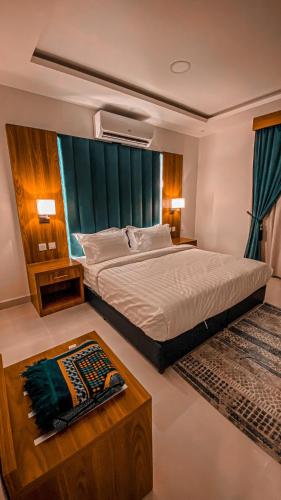 a bedroom with a large bed and a coffee table at هوتيل القصيم 2 للشقق الفندقية in Buraydah