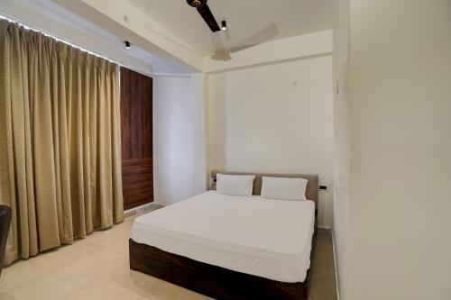 a bedroom with a white bed and a window at Manyawar Hotel in Kaliānpur