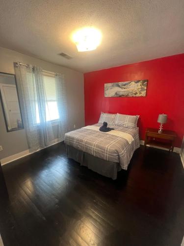 een rode slaapkamer met een bed en een rode muur bij Home away from home in Kingsport