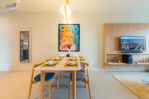 a dining room with a wooden table and chairs at Son&Henry Zenity District 1 in Ho Chi Minh City