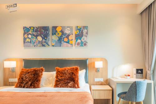 a bedroom with a bed with orange pillows at Son&Henry Zenity District 1 in Ho Chi Minh City
