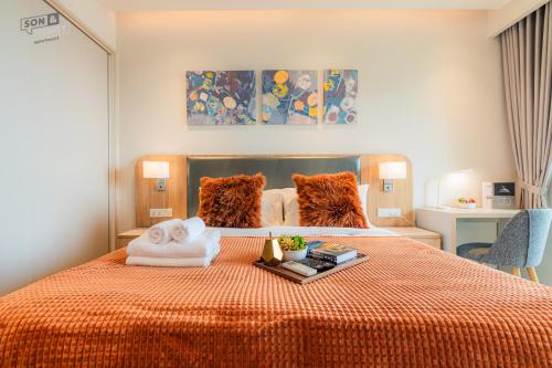 a bedroom with a bed with a pile of towels on it at Son&Henry Zenity District 1 in Ho Chi Minh City