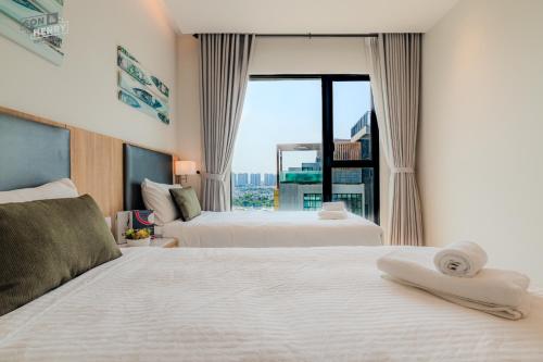 a hotel room with two beds and a large window at Son&Henry Zenity District 1 in Ho Chi Minh City