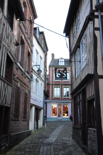 an alley with buildings and a building with a sign on it at Chambres chez l'habitant Capucine in Honfleur
