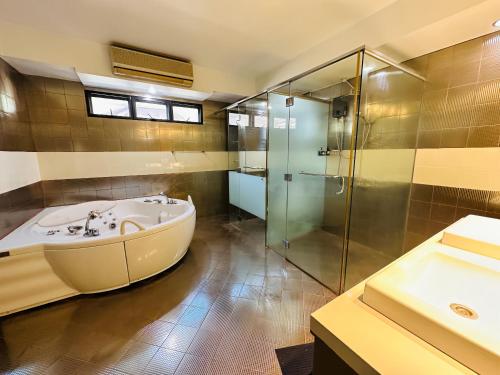 a bathroom with a tub and a shower and a sink at LarisZone-Luxury Courtyard Villa-Near T1 Free Airport Pick up in Manila
