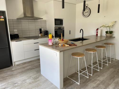 a kitchen with a island with bar stools in it at Place for a Holiday in Papamoa