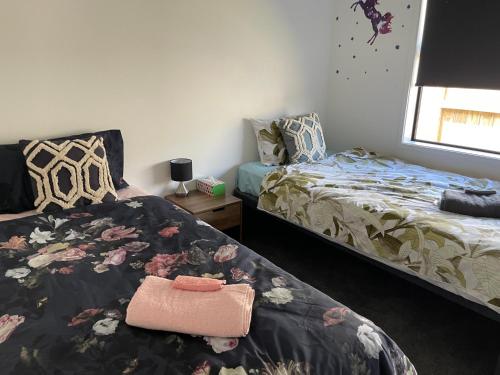 a bedroom with two beds and a bag on the bed at Place for a Holiday in Papamoa