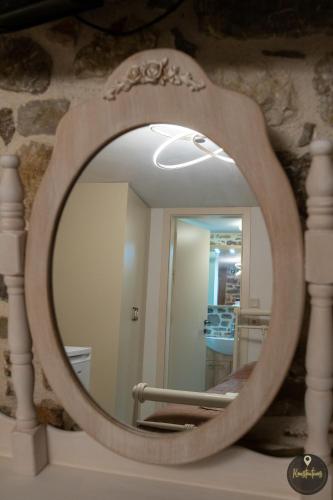 a mirror with a wooden frame on a table at SKINOS rooms and apartment in Pyrgi