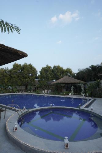 a large swimming pool with blue water at Vanya in Bengaluru