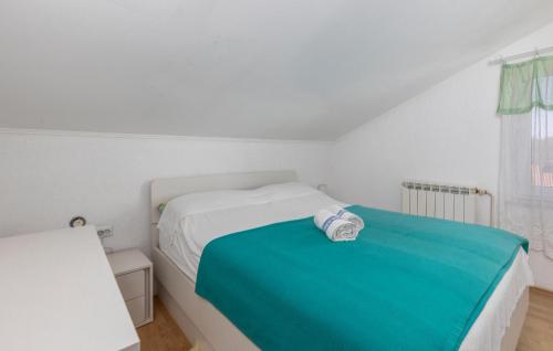 een witte slaapkamer met een bed met een blauwe deken bij Cozy Apartment In Rijeka With Wi-fi in Rijeka